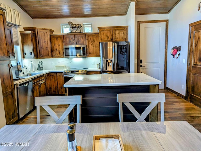 kitchen with stainless steel appliances, dark wood-type flooring, a sink, wood ceiling, and a center island