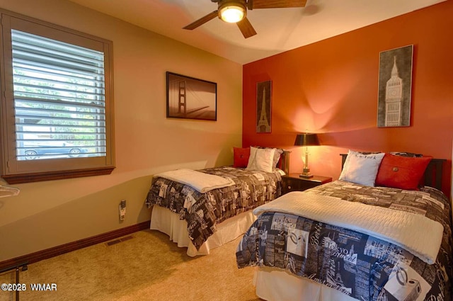 carpeted bedroom featuring a ceiling fan, visible vents, and baseboards