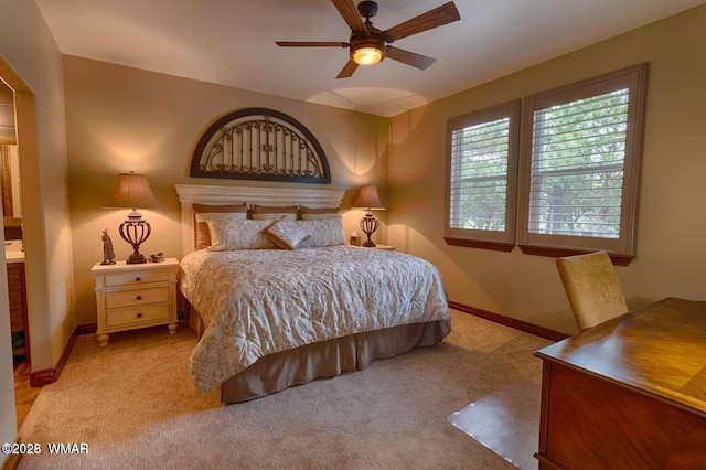 bedroom featuring light carpet, a ceiling fan, and baseboards