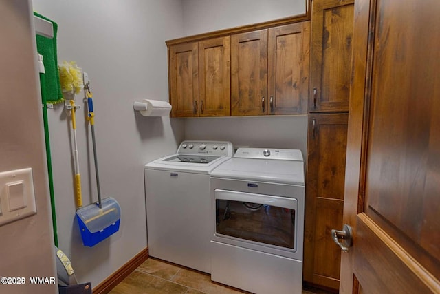 laundry room featuring cabinet space, washer and clothes dryer, baseboards, and light tile patterned floors