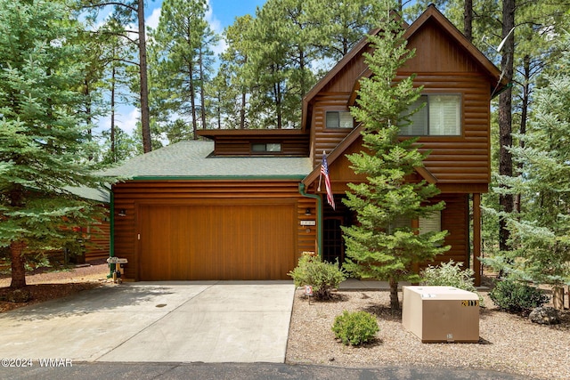 log cabin featuring a garage, concrete driveway, roof with shingles, and log veneer siding