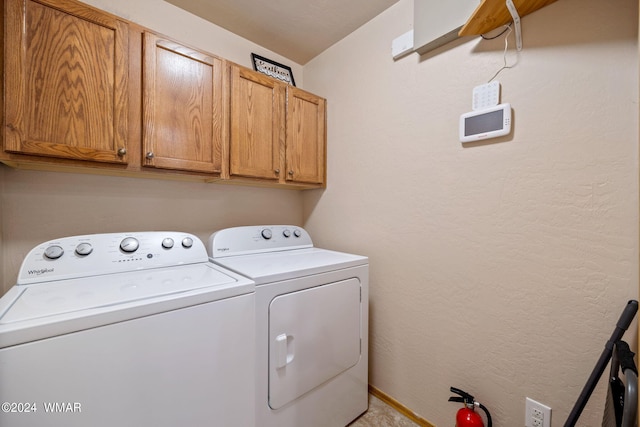 clothes washing area featuring cabinet space, a textured wall, and independent washer and dryer