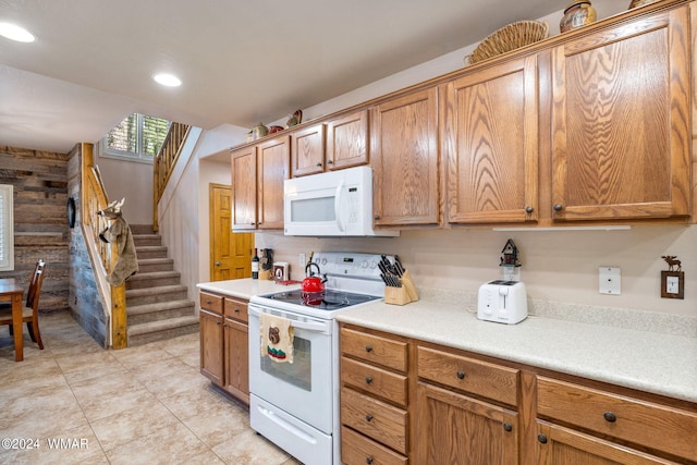 kitchen with brown cabinetry, recessed lighting, white appliances, and light countertops