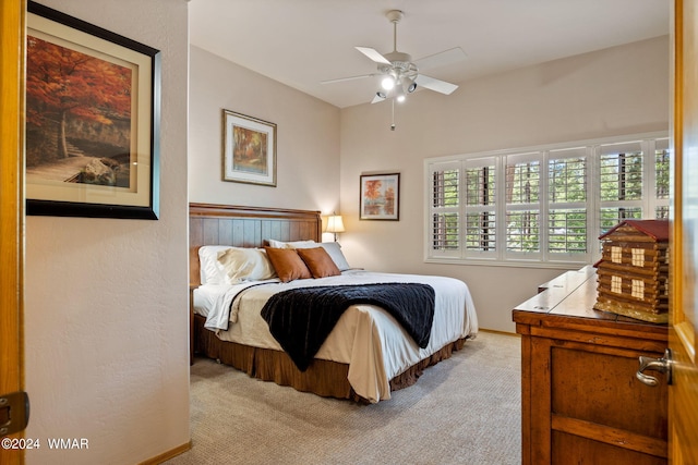 bedroom with light carpet, a ceiling fan, and baseboards