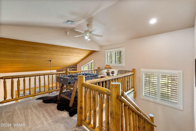 hallway with vaulted ceiling, carpet, an upstairs landing, and visible vents