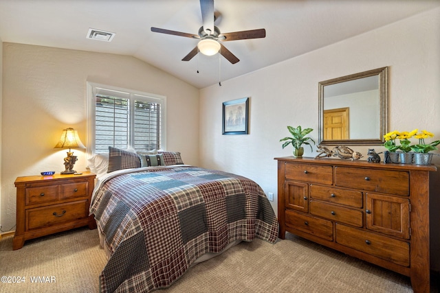 bedroom featuring visible vents, vaulted ceiling, light carpet, and ceiling fan