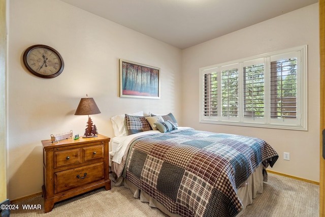 bedroom featuring light carpet and baseboards