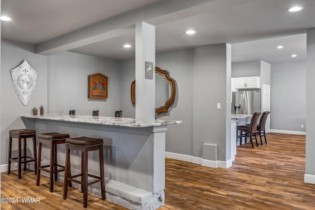 bar with stainless steel fridge with ice dispenser, recessed lighting, dark wood finished floors, and baseboards