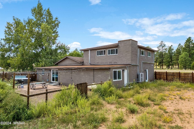 back of property featuring cooling unit, fence, and a patio