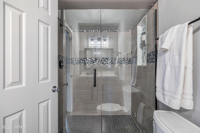 bathroom featuring a shower stall and toilet