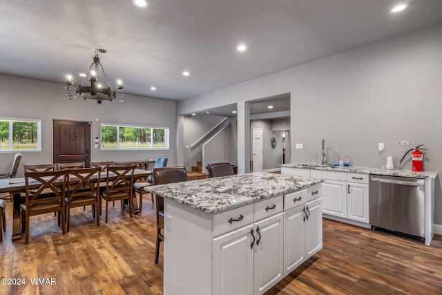 kitchen with white cabinetry, hanging light fixtures, a center island, dishwasher, and dark wood finished floors