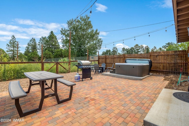 view of patio with a fenced backyard, a grill, and a hot tub