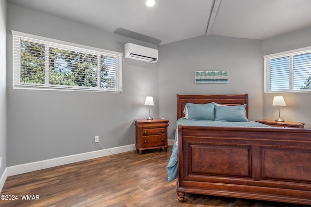 bedroom with lofted ceiling, baseboards, dark wood-type flooring, and a wall mounted air conditioner