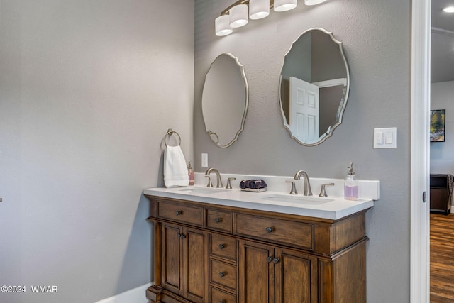 full bath with double vanity, wood finished floors, and a sink