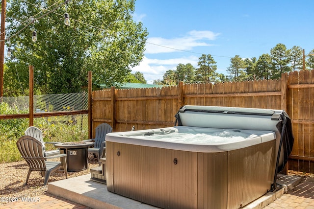 view of patio / terrace featuring a hot tub and fence