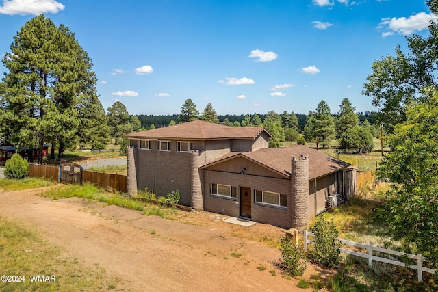 view of front of home with driveway, fence, and brick siding