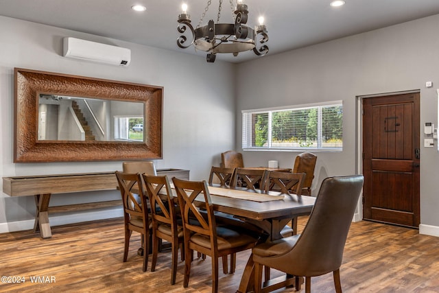 dining area with baseboards, wood finished floors, an inviting chandelier, an AC wall unit, and recessed lighting