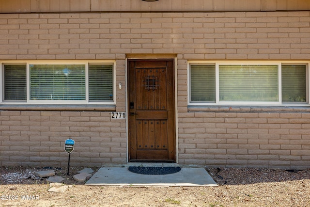 view of exterior entry with brick siding