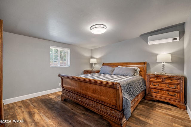 bedroom featuring an AC wall unit, dark wood-type flooring, and baseboards