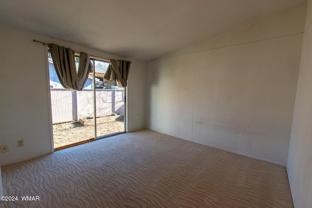 carpeted empty room featuring lofted ceiling