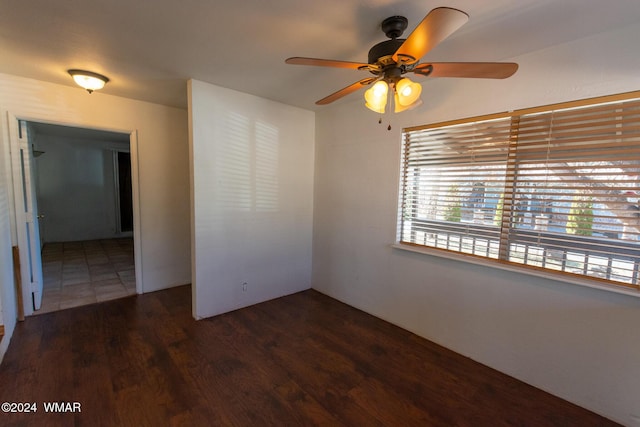 empty room with dark wood-type flooring and a ceiling fan