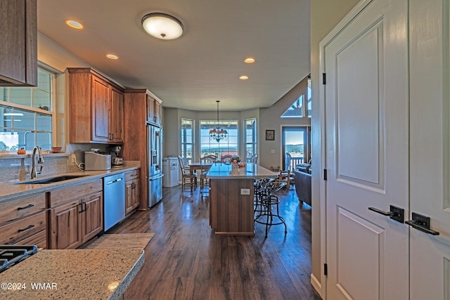 kitchen featuring a breakfast bar, dark wood-style floors, pendant lighting, and stainless steel appliances