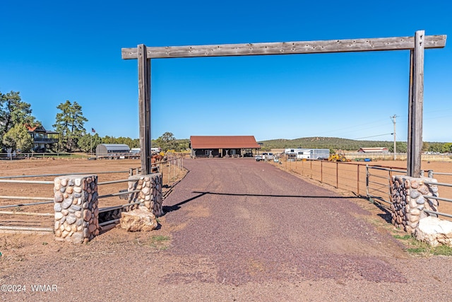 view of street featuring a gated entry and dirt driveway