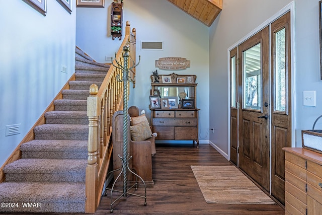 entryway with dark wood finished floors, visible vents, stairway, vaulted ceiling, and baseboards