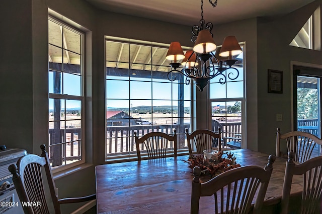 dining room featuring a wealth of natural light, a notable chandelier, and wood finished floors