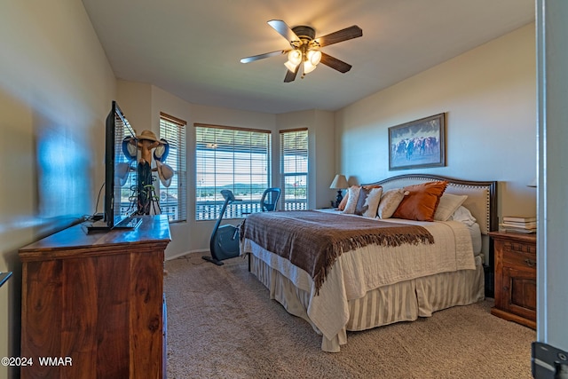 bedroom with a ceiling fan and light colored carpet