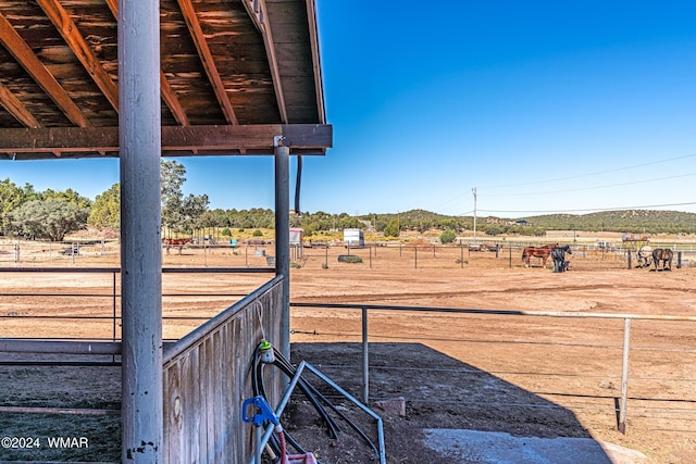 view of yard featuring an enclosed area, an exterior structure, and a rural view