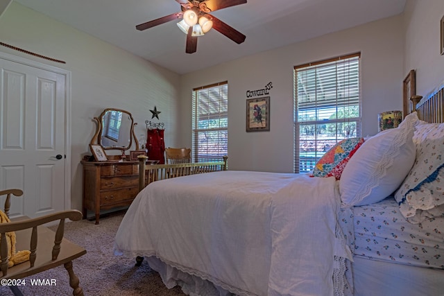 carpeted bedroom with multiple windows and a ceiling fan