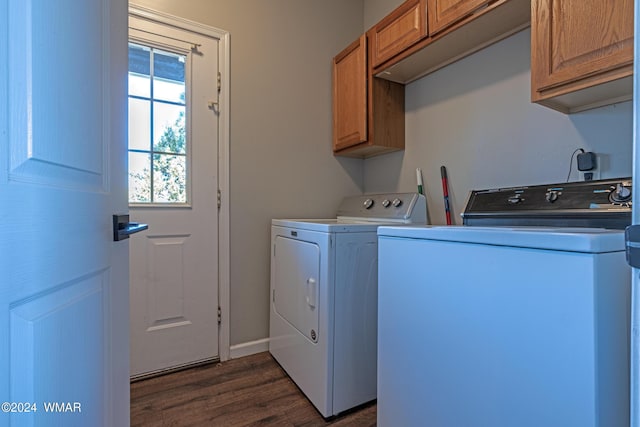 clothes washing area with dark wood-type flooring, washing machine and dryer, and cabinet space