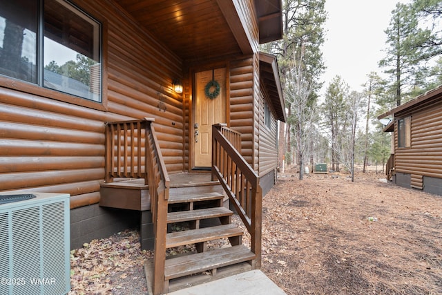 property entrance featuring crawl space, faux log siding, and central AC