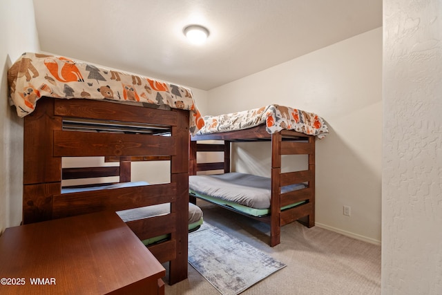 bedroom featuring light carpet and baseboards