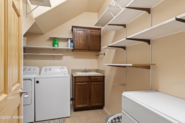 washroom with cabinet space, light tile patterned floors, a sink, and independent washer and dryer