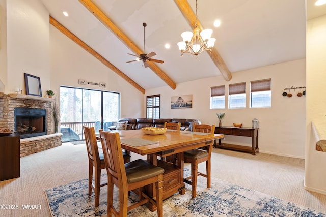 dining space with high vaulted ceiling, beamed ceiling, a stone fireplace, and light colored carpet