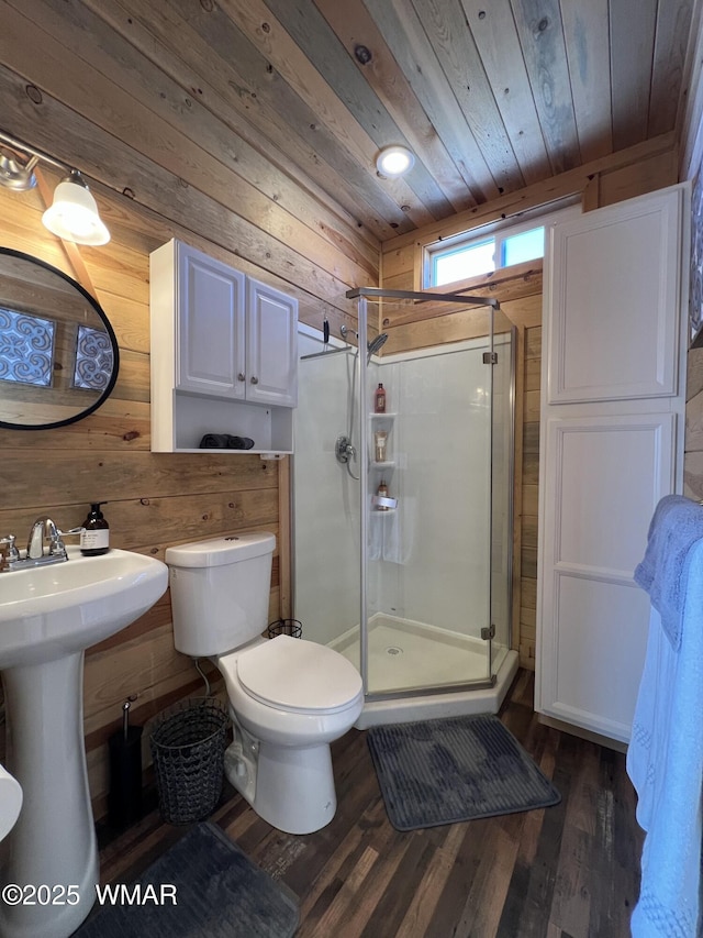 full bathroom with toilet, wooden walls, wood finished floors, wood ceiling, and a shower stall