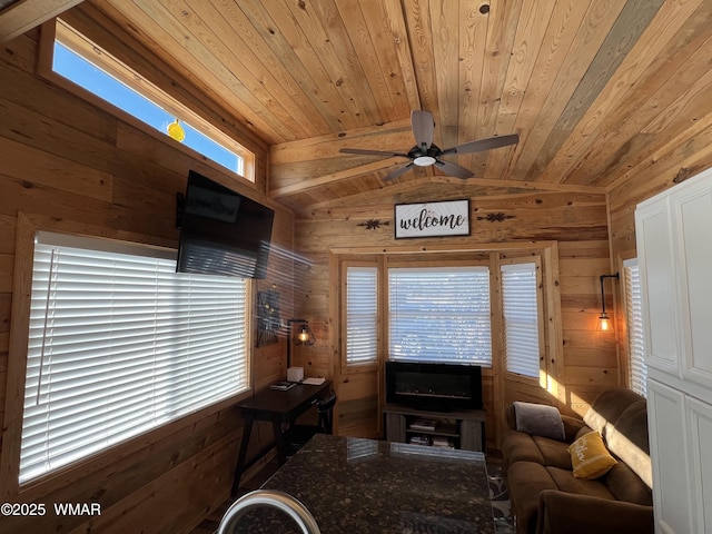 living room with lofted ceiling, wood ceiling, wooden walls, and ceiling fan