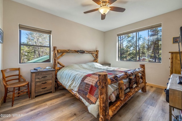 bedroom featuring a ceiling fan, baseboards, and wood finished floors