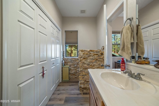 full bath featuring visible vents, vanity, and wood finished floors