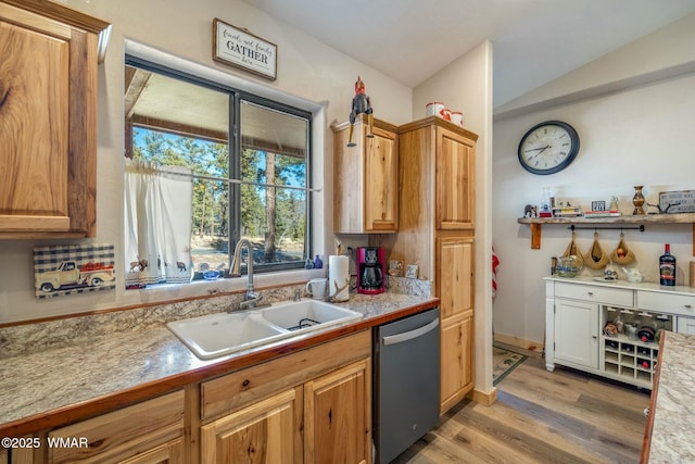 kitchen with brown cabinets, light countertops, light wood-style flooring, a sink, and dishwasher