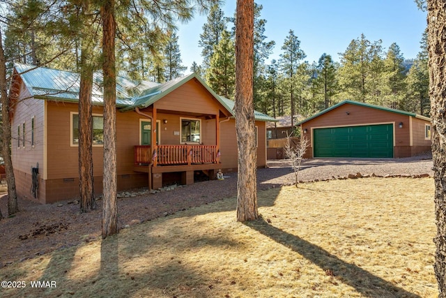 view of front facade with metal roof, a porch, a garage, an outdoor structure, and crawl space