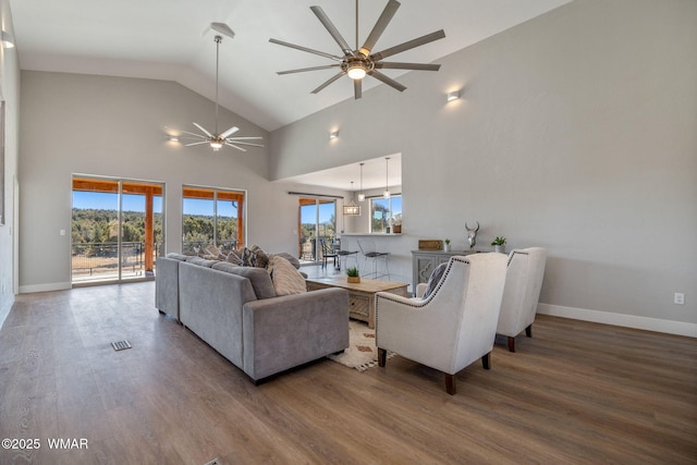 living area with ceiling fan, high vaulted ceiling, wood finished floors, visible vents, and baseboards