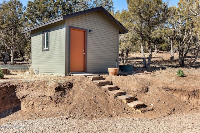 view of outbuilding featuring fence and an outdoor structure