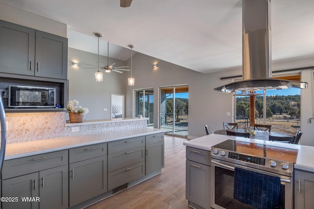 kitchen featuring island range hood, lofted ceiling, gray cabinets, light countertops, and stainless steel range with electric cooktop