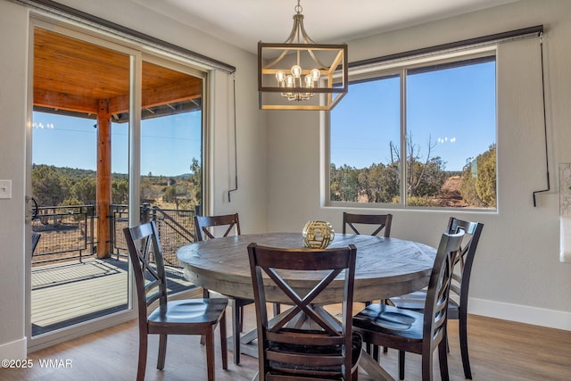 dining space with a notable chandelier, baseboards, a wealth of natural light, and wood finished floors