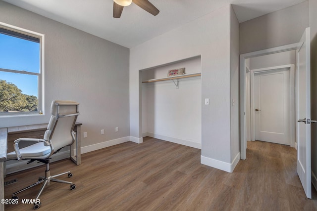 office area with light wood-type flooring, baseboards, and a ceiling fan