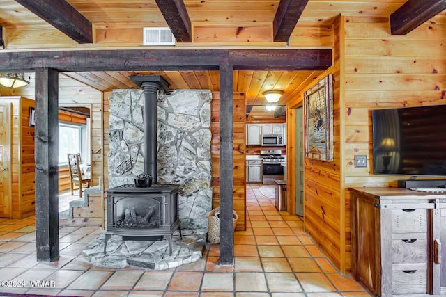 6436 Mark Twain Dr, Pinetop, AZ 85935 - kitchen featuring appliances with stainless steel finishes, wooden ceiling, beamed ceiling, a wood stove, and light tile patterned flooring