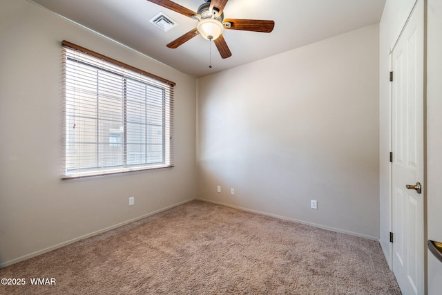 carpeted spare room featuring visible vents, ceiling fan, and baseboards